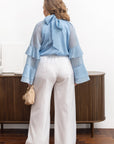Stylish women’s blouse with ruffles and a high neckline от марка YR, tencel и cotton, изображена на модел.