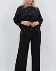 Velvet dress with pearls, with an elegant design and data for composition of viscose, cotton and elastane, image of a model.