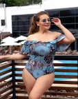 One-piece swimsuit с принт и волани, произведен от 100% polyester, показан в изображението.