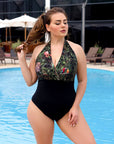 One-piece swimsuit от polyester, модел с цветен дизайн, лежащ на плажна пясъчна повърхност.