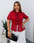 Lace blouse made from cotton and nylon, with delicate design and sheer details, suitable for elegant style.