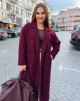 Long faux-cashmere coat with polyester, viscose and wool, shown on a model, stylish and warm for the winter season.