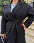 Long faux-cashmere coat with polyester, viscose and wool, shown on a model, suitable for autumn and winter.