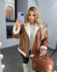 Short faux leather coat, 100% polyamide, image of a stylish model with a modern look.