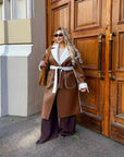 Long faux leather coat, 100% polyamide, shown on a woman, ideal for winter style and comfort.