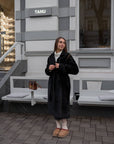 Long mixed-fabric coat in polyester and spandex, with a fashionable design, as shown in the image.