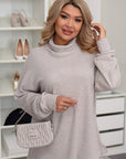 Soft light grey high-neck pullover worn by a woman, with a bag and shoes on the shelf in the background.
