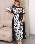 Floral midi dress от polyester, носена на модел, с ярки флорални мотиви и елегантен дизайн.