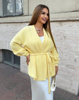 Cropped cardigan with a belt made from cotton and polyester, with fashionable design, shown on a model in the photo.