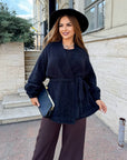 Cropped cardigan with a belt made from polyester and viscose, model in black, shown on a model, suitable for everyday style.