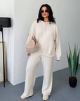 Soft ribbed-knit set with a composition of polyester 70%, viscose 25%, elastane 5%, lying on soft surface.