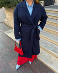 Long faux-cashmere coat with polyester, viscose and wool, with an elegant design, shown on a model.