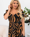 Woman wearing a black and brown patterned dress in a room with white walls and decorative elements.