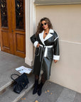 Long faux leather coat, modern design, in black, with a collar and long sleeves, polyester.