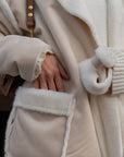Long mixed-fabric coat in polyester and spandex, with a clean design and elegant silhouette, shown on a model.