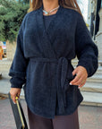 Cropped cardigan with a belt made from polyester and viscose, in the photo is in white, with accent on the design and the texture.